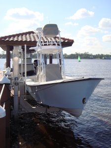 A boat elevator built off a dock holds a small v-hull watercraft.